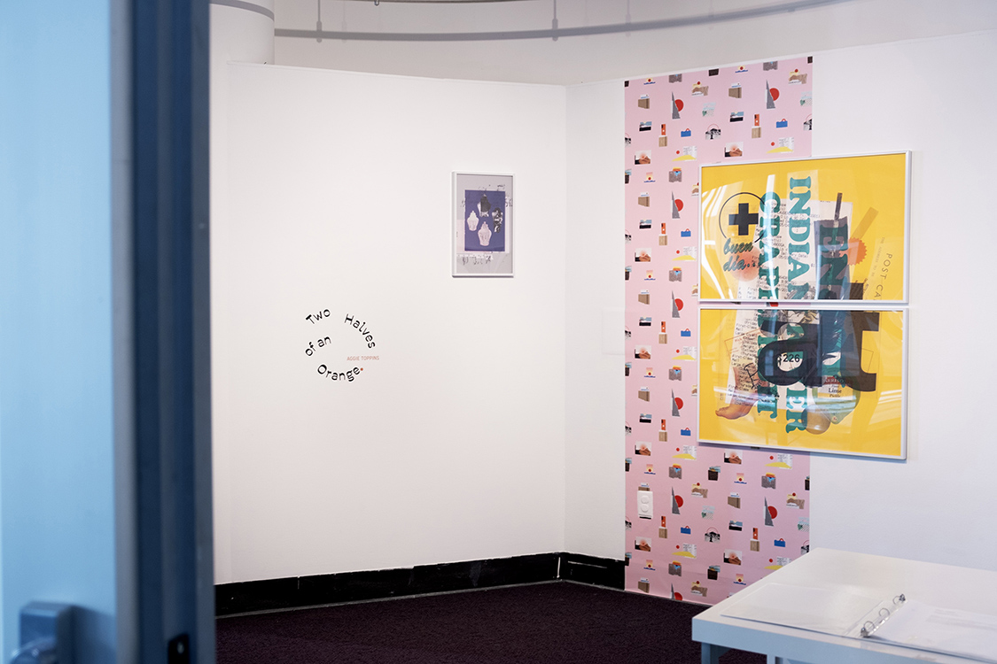 A gallery entry way with a title wall, a strip of wallpaper, and framed artwork